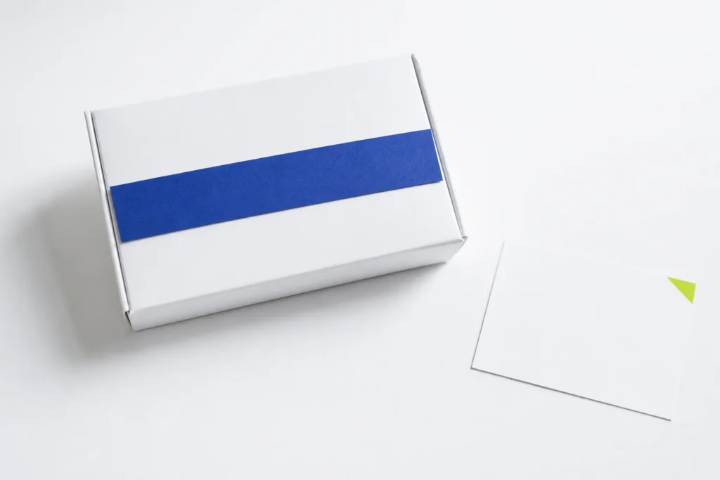 Gesloten witte productdoos met afgedekte marketingnaam naast een afzonderlijke blanco ingrediëntenkaart.